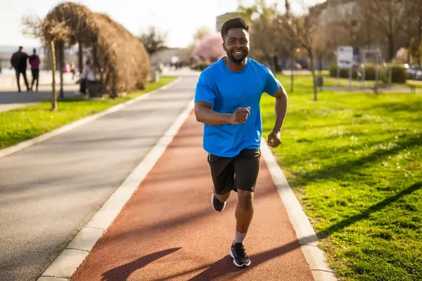 アフリカ系アメリカ人の若者が街でジョギングをしている — ストック写真
