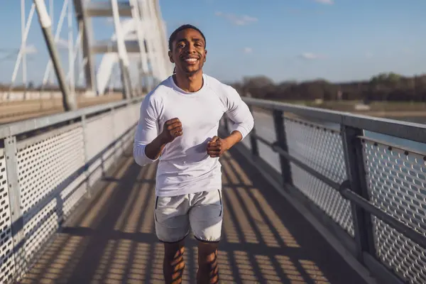 Ung Afrikansk Amerikansk Man Joggar Bron Staden Stockbild