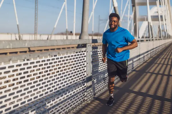 Young African American Man Jogging Bridge City Stock Image