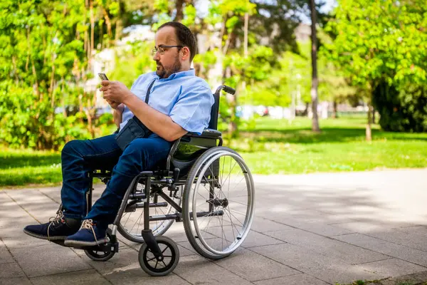 Portrait Man Wheelchair Enjoying Sunny Day City Park Messaging Smartphone Stock Photo