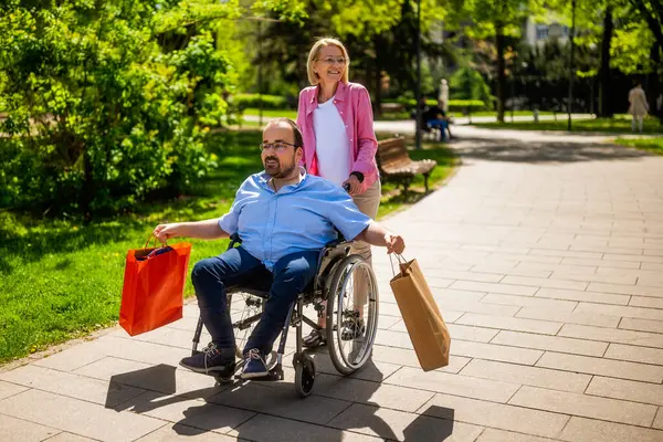 Man Wheelchair Going Shopping His Friend Assisting Him Rolling Wheelchair Royalty Free Stock Images