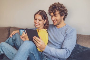 Evdeki mutlu genç çiftin portresi. Kanepede dinleniyorlar..