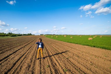 Afrikalı çiftçi tarlasında duruyor. O yonca yetiştiriyor ve saman balyaları yapıyor..