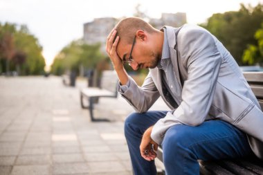 Aşırı çalışan ve depresyonda olan bir adamın portresi. O, şehirde bankta oturuyor..