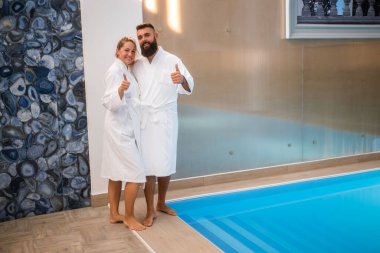 Genç mutlu çift yüzme havuzunun yanındaki spa merkezinde eğleniyor. Erkek ve kadın tatilde..