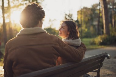 Mutlu ve sevgi dolu bir çift parkta eğleniyor. Erkek ve kadın kucaklaşır.