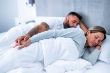 Genç evli çift yataklarında uyuyor. El ele tutuşup güzel bir uyku çekiyorlar..