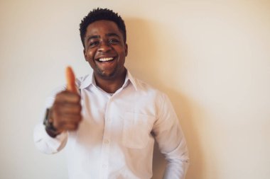 Gülümseyen ve baş parmağını kaldıran mutlu bir adamın portresi. Metnin ya da ilanın için resim üzerine boşluk kopyala.