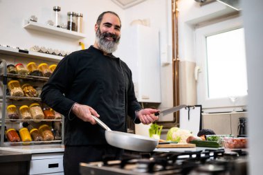 Restoranın mutfağında çalışan profesyonel şefin portresi. Yemek hazırlamaya hazır..
