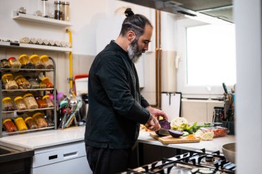 Profesyonel şef restoranın mutfağında yemek hazırlıyor. Vejetaryen yemeği yapar..