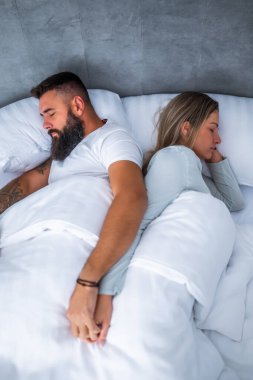 Genç evli çift yataklarında uyuyor. El ele tutuşup güzel bir uyku çekiyorlar..