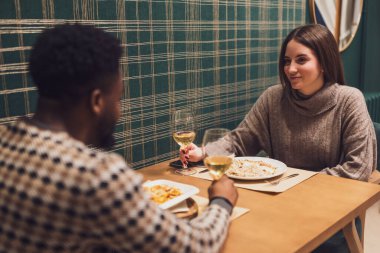 İki arkadaş restoranda akşam yemeği yiyorlar. Oturuyorlar, konuşuyorlar ve birlikte vakit geçiriyorlar..