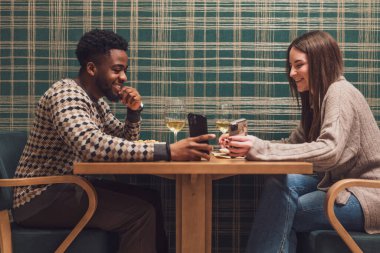 İki arkadaş restoranda akşam yemeği yiyorlar. Oturuyorlar, konuşuyorlar ve birlikte vakit geçiriyorlar..