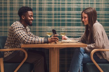 İki arkadaş restoranda akşam yemeği yiyorlar. Oturuyorlar, konuşuyorlar ve birlikte vakit geçiriyorlar..