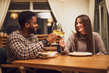 İki arkadaş restoranda akşam yemeği yiyorlar. Şarapla kadeh kaldırıyorlar..