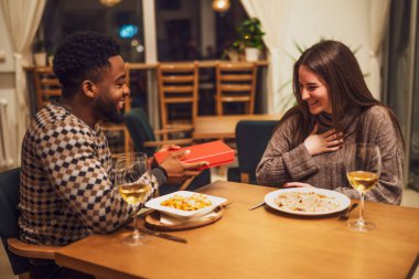 İki arkadaş restoranda akşam yemeği yiyorlar. Birbirlerine hediye veriyorlar..