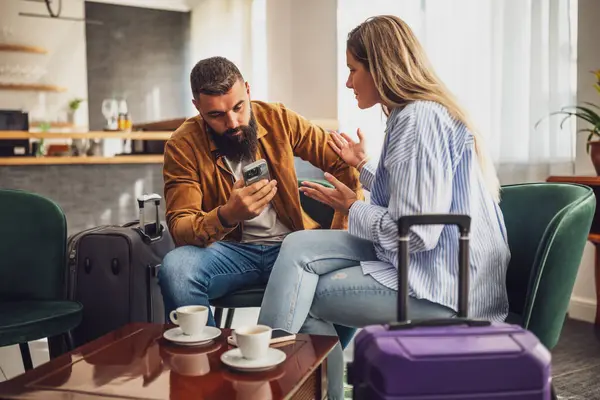 Yetişkin çift tatile çıkıyor. Havaalanındaki kafede oturuyorlar ve kontrol için bekliyorlar..