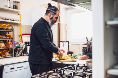 Profesyonel şef restoranın mutfağında yemek hazırlıyor. Vejetaryen yemeği yapar..