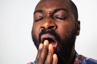 Esnemekte olan yorgun ve bitkin siyah adamın portresi.