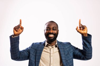 Mutlu ve başarılı bir iş adamının portresi. Takım elbiseli siyah adam iki eliyle işaret ediyor..