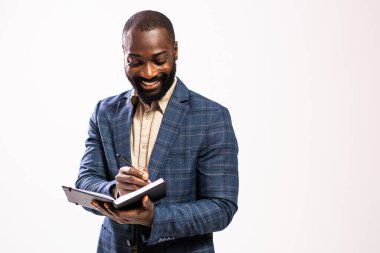 Mutlu ve başarılı bir iş adamının portresi. Siyah takım elbiseli adam not defterine yazıyor..