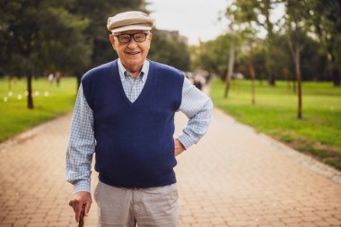 Park 'taki mutlu son sınıf öğrencisinin portresi. Güneşli bir günde dinleniyor ve yürüyor..