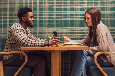 İki arkadaş restoranda akşam yemeği yiyorlar. Oturuyorlar, konuşuyorlar ve birlikte vakit geçiriyorlar..