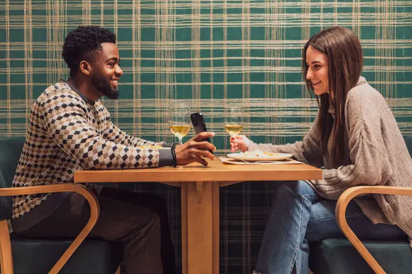 İki arkadaş restoranda akşam yemeği yiyorlar. Oturuyorlar, konuşuyorlar ve birlikte vakit geçiriyorlar..