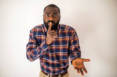 Sessizlik isteyen perişan ve ciddi bir siyah adamın portresi..