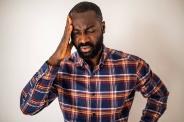 Endişeli ve başı ağrıyan siyah bir adamın portresi. Yetişkin adam yorgun ve çok çalışıyor..