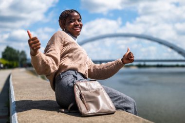 Neşeli genç siyah kadın güneşli bir günün tadını çıkarıyor..