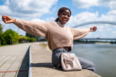 Neşeli genç siyah kadın güneşli bir günün tadını çıkarıyor..