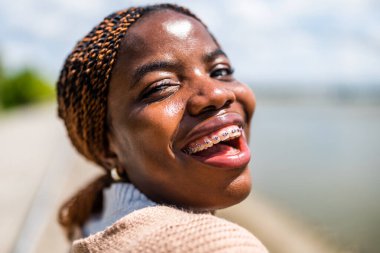 Diş teli takan neşeli siyahi kadının portresini yakından çek..