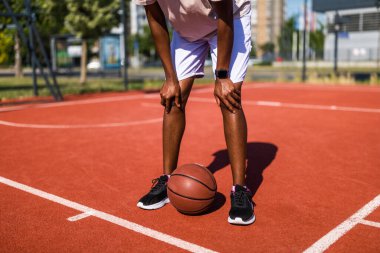Basketbol sahasında dikilen genç siyahi kadını yakından çek. Oynamaktan ve ara vermekten bıktı..