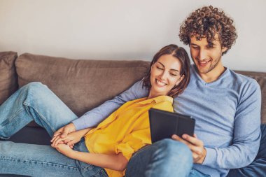 Evdeki mutlu genç çiftin portresi. Kanepede dinleniyorlar..