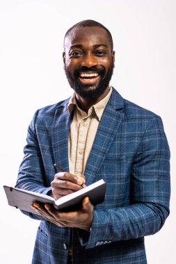 Mutlu ve başarılı bir iş adamının portresi. Siyah takım elbiseli adam not defterine yazıyor..