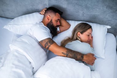 Genç evli çift yataklarında uyuyor. İyi uykular ve kucaklaşmalar..