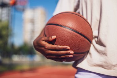 Basketbol oynayan genç bayana yakın çekim. Güneşli bir günde basketbol çalışıyor..