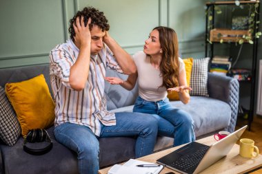 Kadın, erkeği çok çalıştığı için kızgın. Serbest çalışan ve kadınıyla tartışan biri..