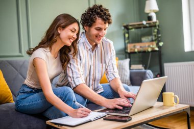 Çift faturaları kontrol ederken ev ekonomisini tartışıyor. Mali belgeleri kontrol ediyorlar ve oturma odasındaki aile bütçesini hesaplıyorlar..