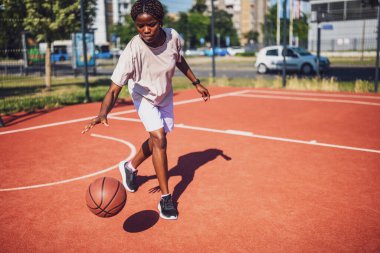Afrikalı bayan basketbolcu tek başına antrenman yaparken salya sürme becerisi uyguluyor..