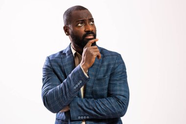 Portrait of worried and thoughtful African-american businessman. Black man in business suit is standing and thinking.