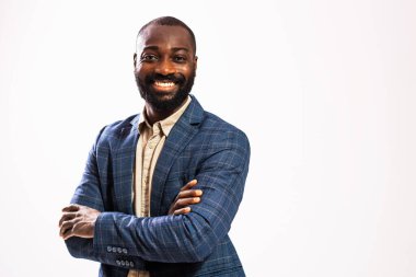 Portrait of happy and successful African-american businessman. Black man in business suit is standing with arms crossed and smiling.