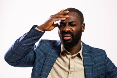 Portrait of tired and exhausted African-american businessman. Black man in business suit is standing and having headache.