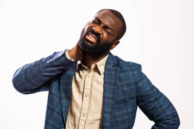 Portrait of tired and exhausted African-american businessman who is having pain in his neck.