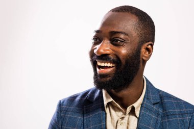 Close up portrait of happy and successful African-american businessman who is looking away and smiling. 