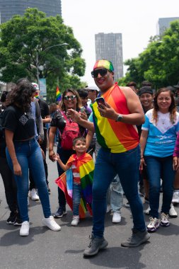 Mexico City, 25 Haziran 2022. Gay Gurur Festivali 'nin katılımcıları, lgbt bayrağını pelerin olarak giyen bir çocukla mutluluğu kutluyorlar..