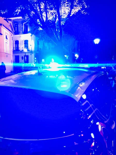 Detail of the Spanish police car. Blue lights with bokeh effect on the roof of a police car with out of focus background. 