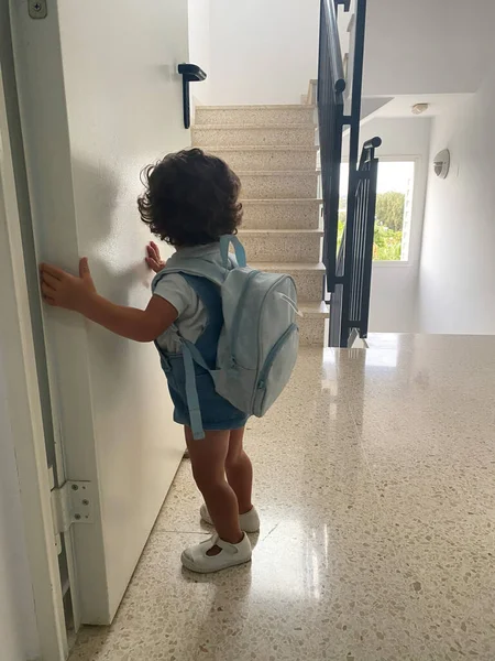 Mutlu çocuk sırtında bir sırt çantasıyla okula gider. Çocuk konsepti. Merdivenin arkasından bir okul çocuğunun görüntüsü..