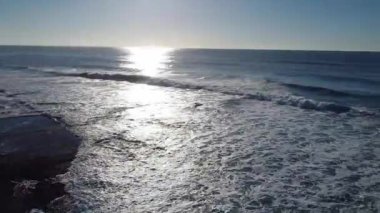 Okyanus dalgaları kumsalda kırılıyor 